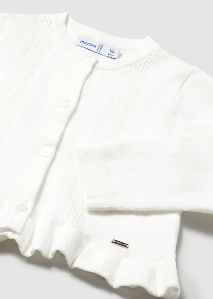 Knitted cardigan with ruffled waist. Button fastening.